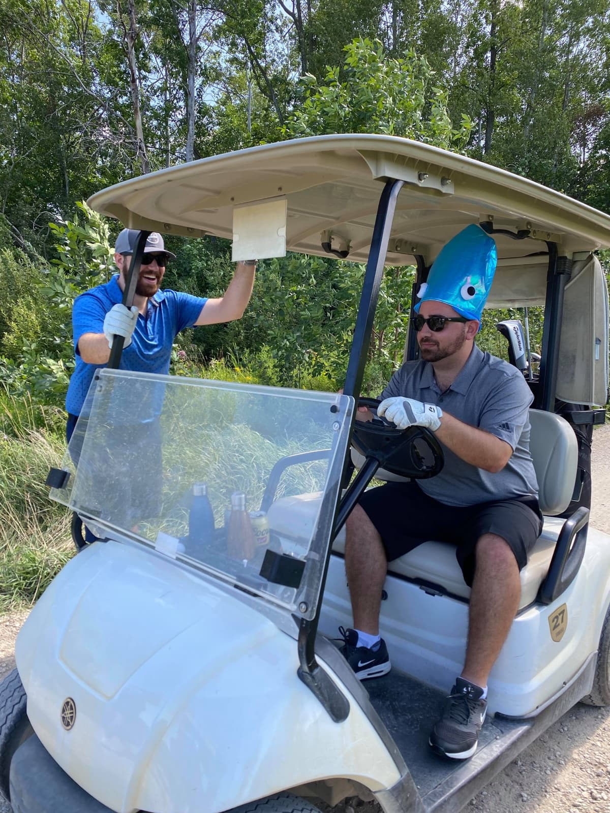 Dave wearing a blue squid hat in a golf cart